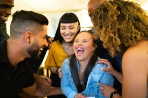 a young woman with special needs surrounded by smiling friends