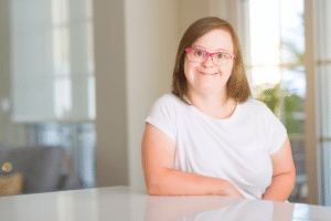 woman with special needs sitting at a table smiling